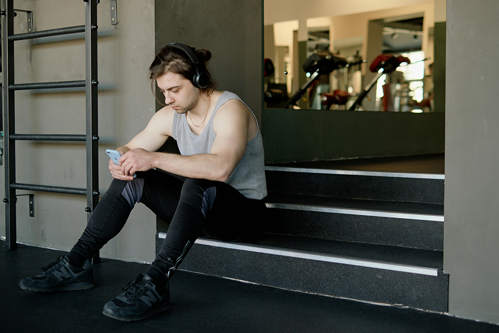 guy at gym listening to headphones
