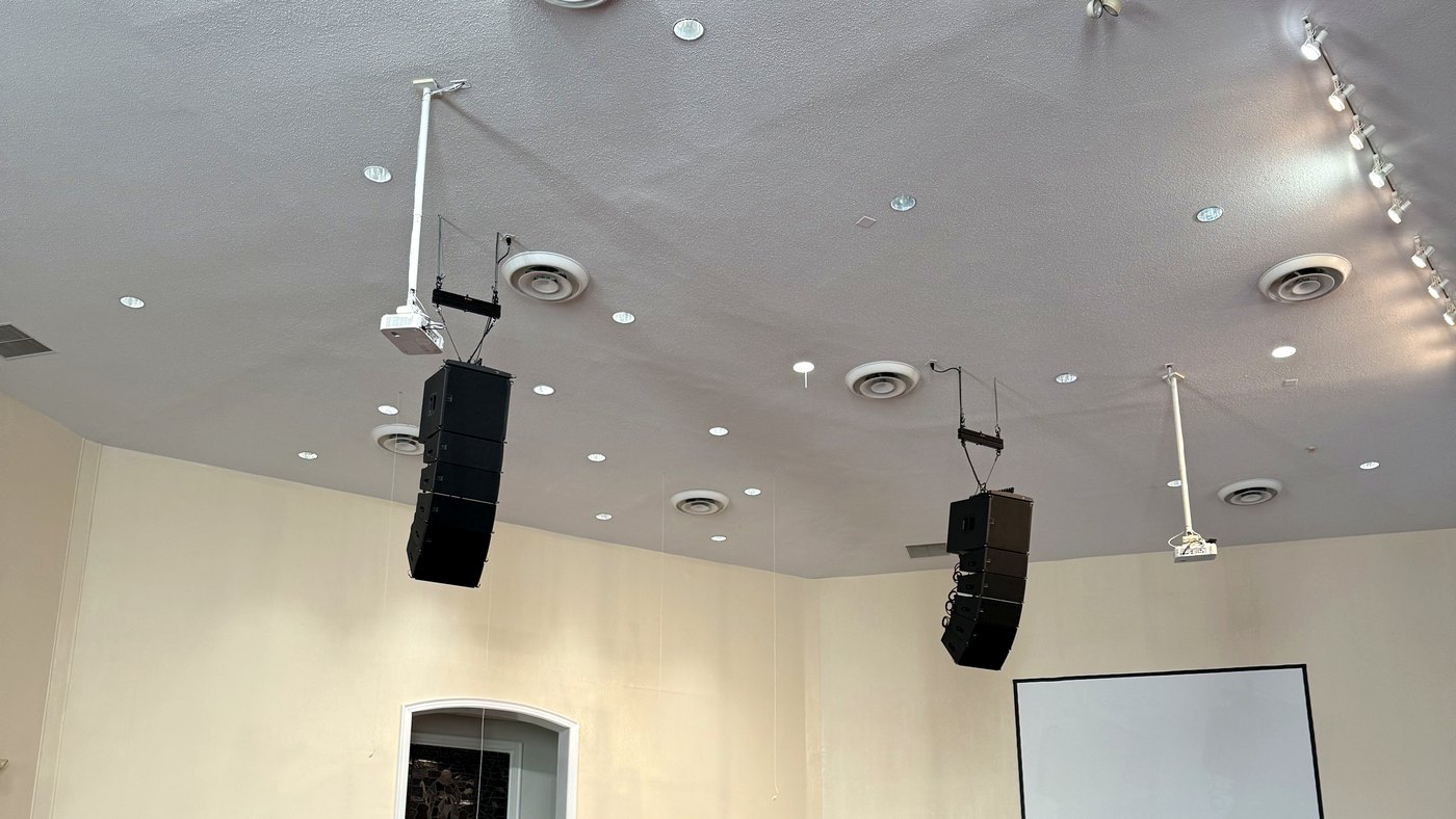 Sanctuary with flown speaker arrays, projection screen, and stained glass installed by Livewire in Central Virginia